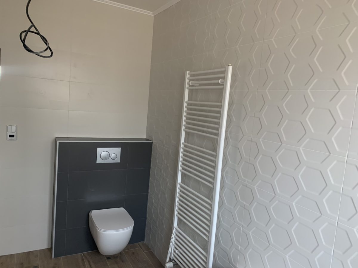 Černobílá moderní koupelna – WC, otopný žebřík