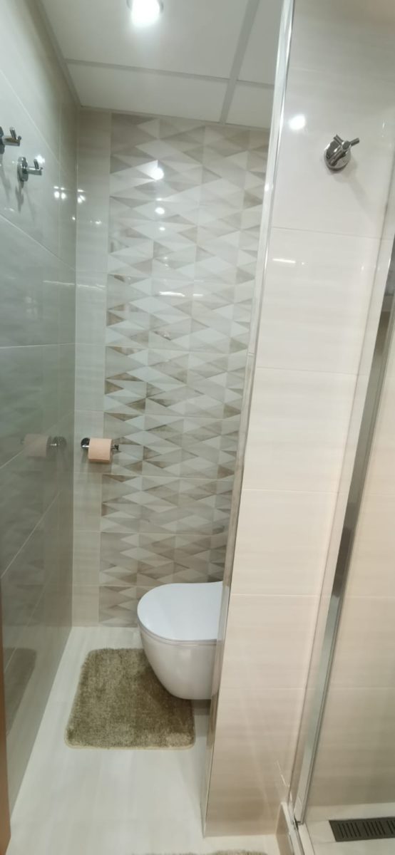 malá světlá koupelna v paneláku s velkým sprchovým koutem s krémovými barvami