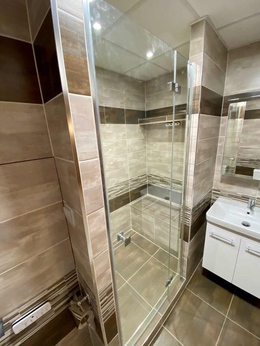Koupelna v panelovém domě s prostorným sprchovým koutem se sedátkem (Most)