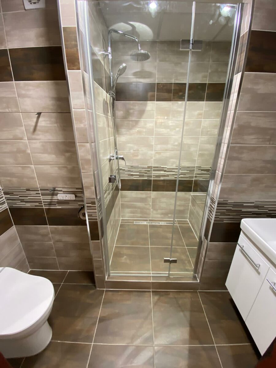 Koupelna v panelovém domě s prostorným sprchovým koutem se sedátkem (Most)