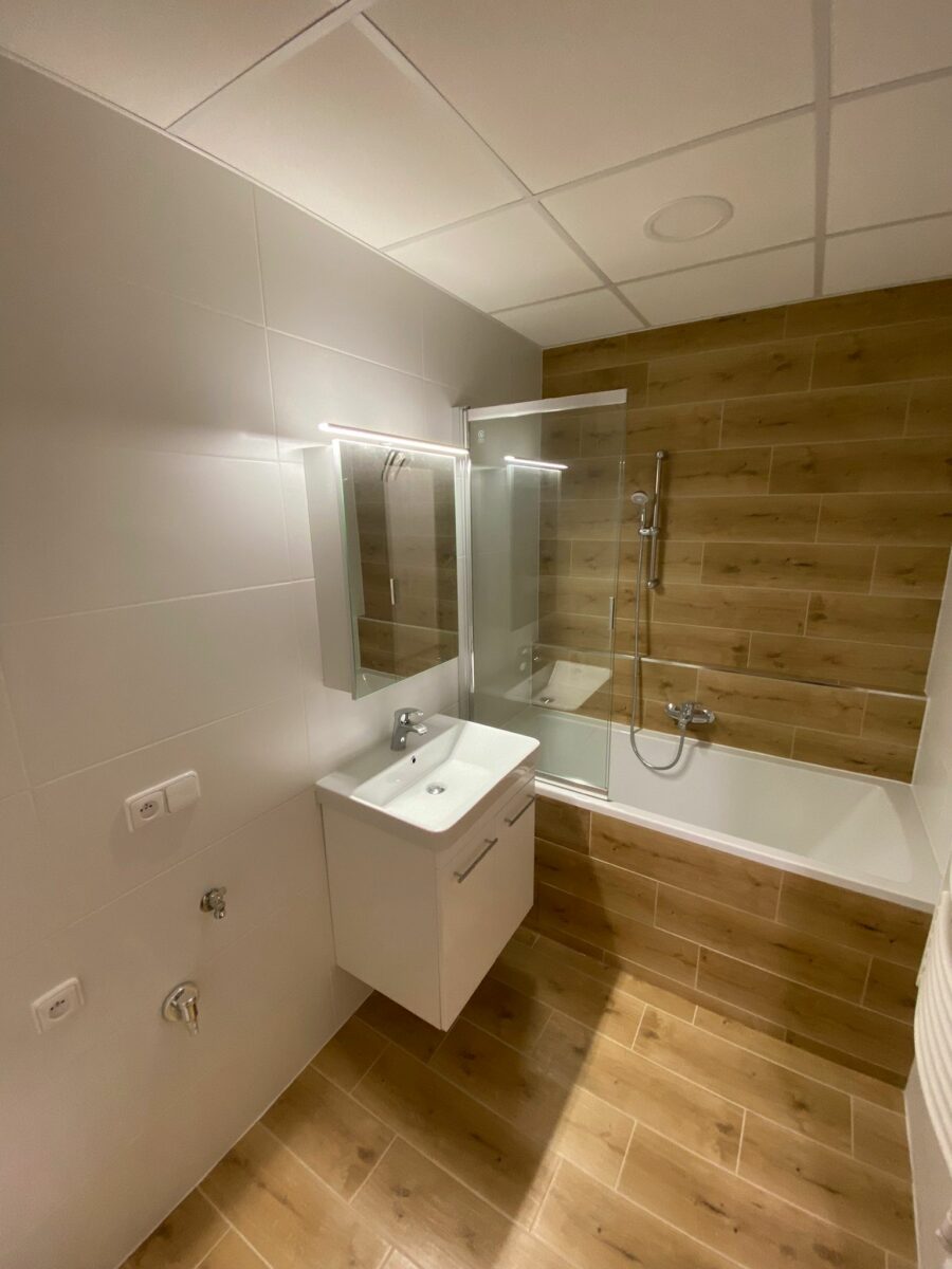 Bílá koupelna v přírodním stylu s dřevěnými prvky (Chomutov)