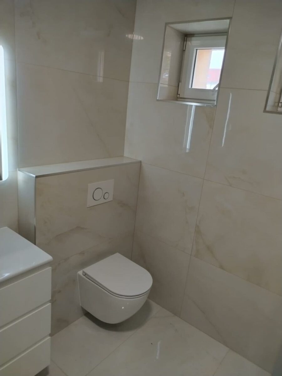 Nadčasová koupelna v dekoru světlého mramoru s velkou sprchou se sedátkem a odtokovým žlabem (Chomutov)