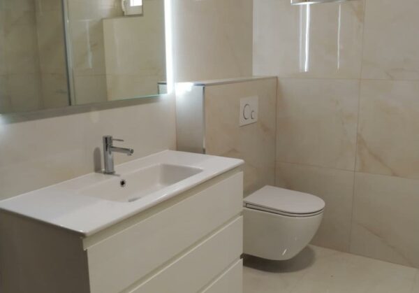 Nadčasová koupelna v dekoru světlého mramoru s velkou sprchou se sedátkem a odtokovým žlabem (Chomutov)