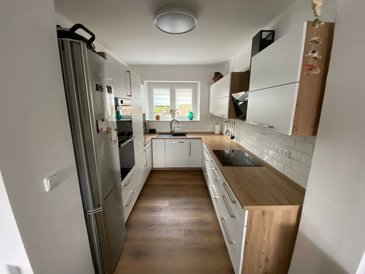 Moderní kuchyně do U s linkou v imitaci dřeva a velkým černým dřezem (Most)