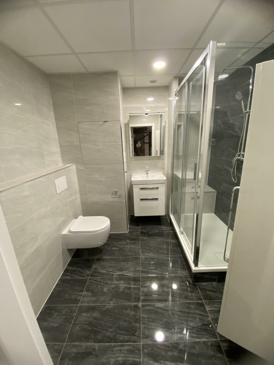 Černobílá koupelna s prostorným sprchovým koutem se sedátkem (Most)