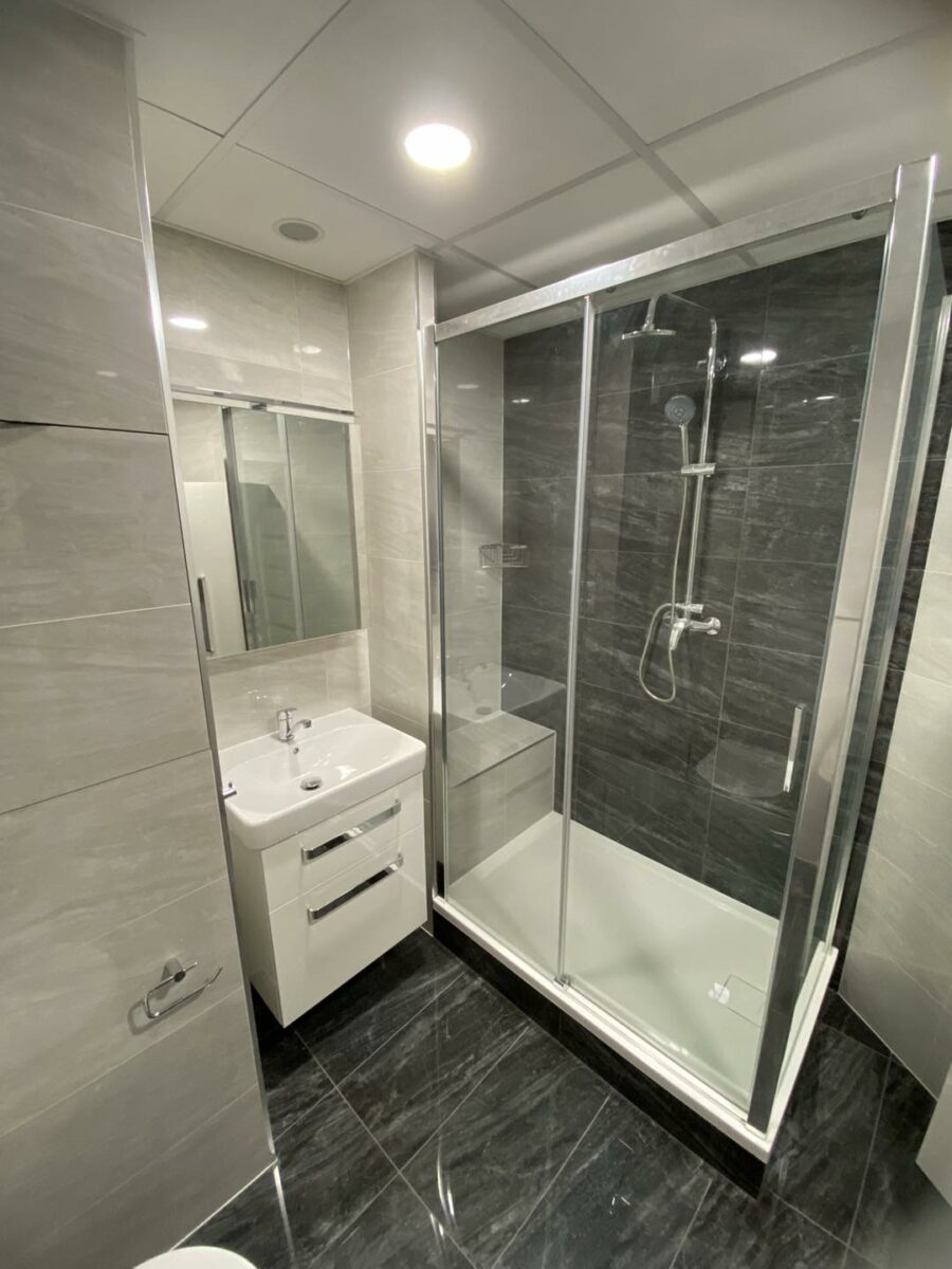 Černobílá koupelna s prostorným sprchovým koutem se sedátkem (Most)