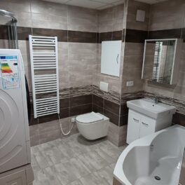 Šedo hnědá paneláková koupelna s velkou vanou i sprchovým koutem (Most)