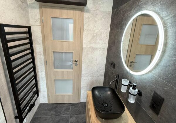 Krásná koupelna s velkoformátovými obklady v dekoru břidlice a černými zařizovacími předměty (Most)