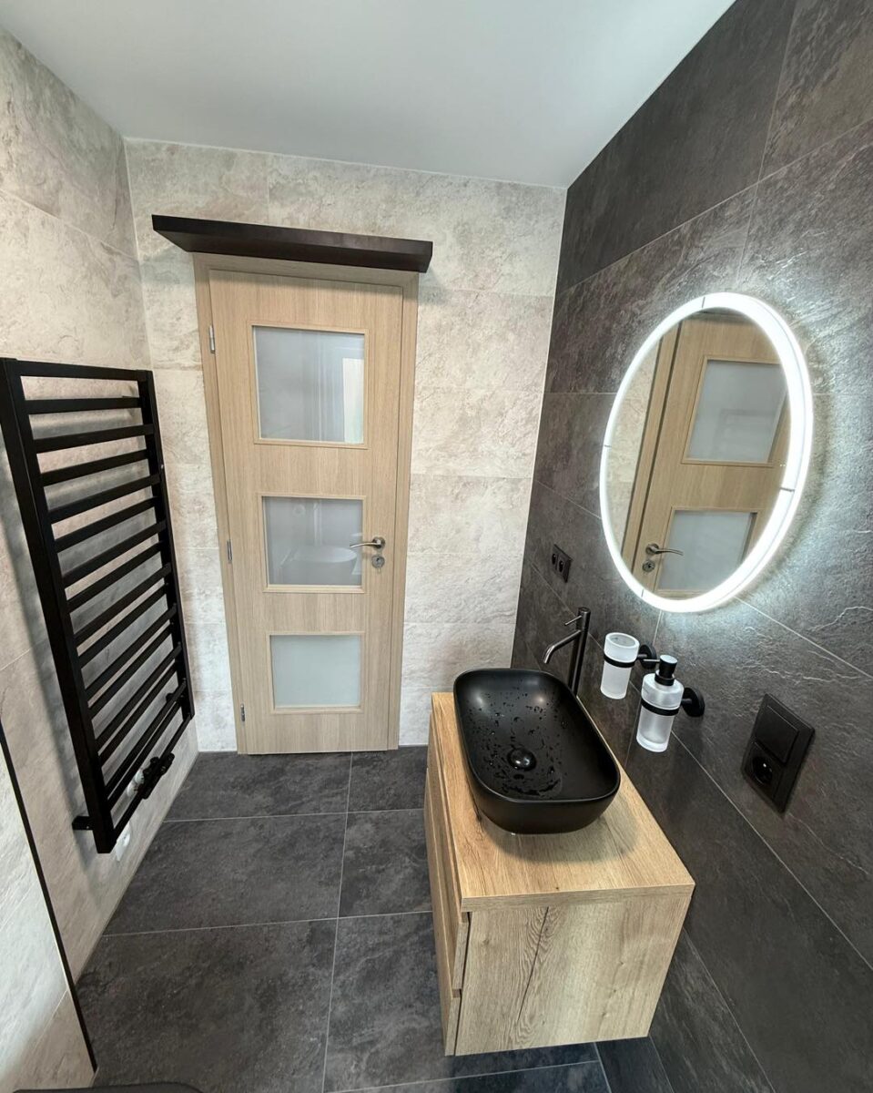 Krásná koupelna s velkoformátovými obklady v dekoru břidlice a černými zařizovacími předměty (Most)