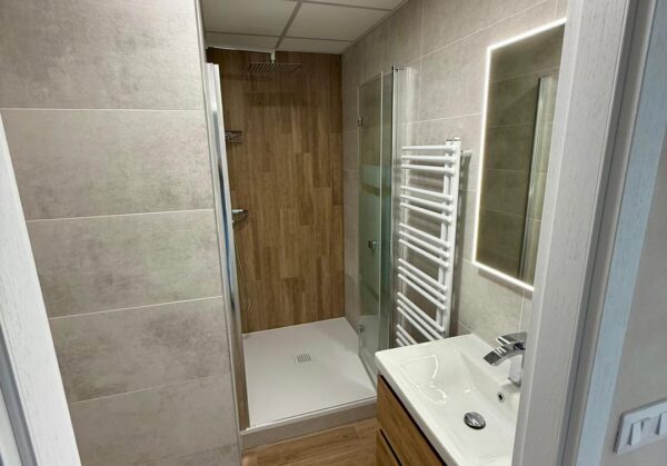 Malá paneláková koupelna ve světlých barvách s dřevodekorem (Kadaň)