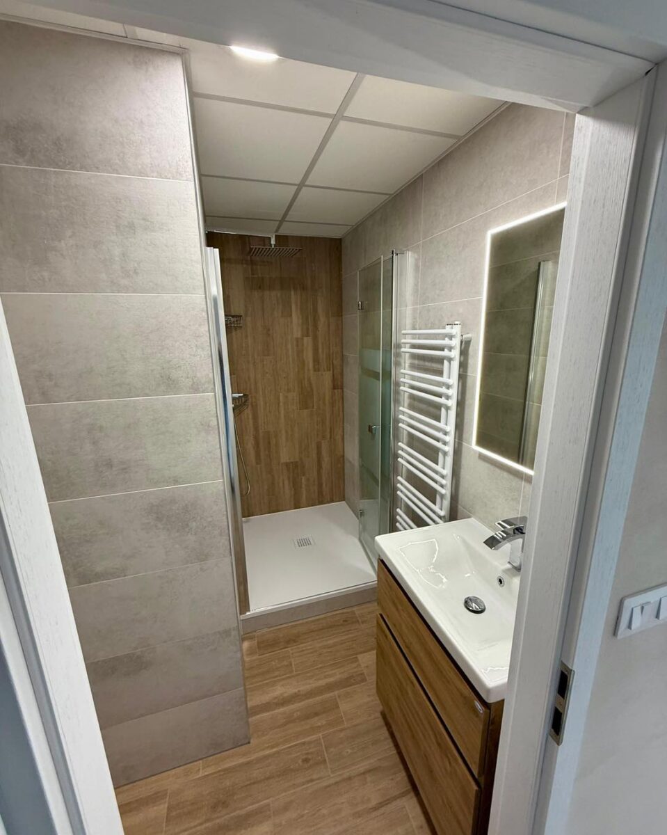 Malá paneláková koupelna ve světlých barvách s dřevodekorem (Kadaň)