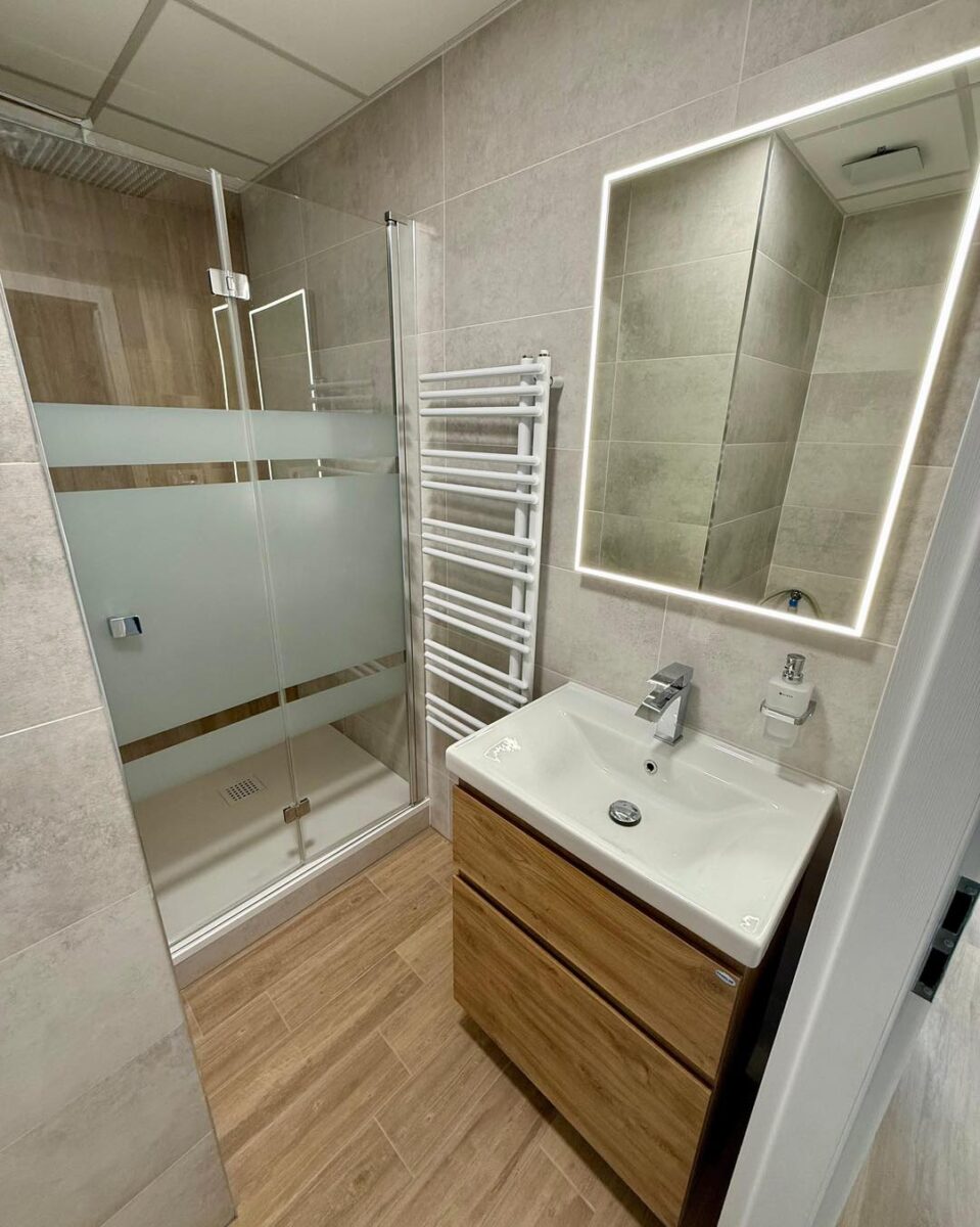 Malá paneláková koupelna ve světlých barvách s dřevodekorem (Kadaň)