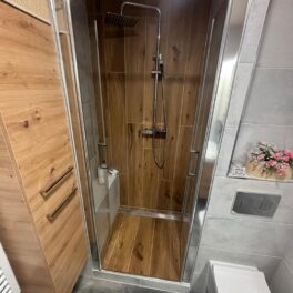 Malá koupelna v dekoru dřeva a kamene se sprchovým koutem s obloženým sedátkem (Žatec)