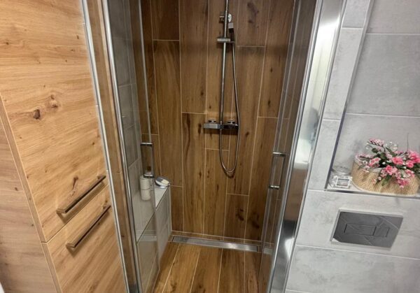 Malá koupelna v dekoru dřeva a kamene se sprchovým koutem s obloženým sedátkem (Žatec)