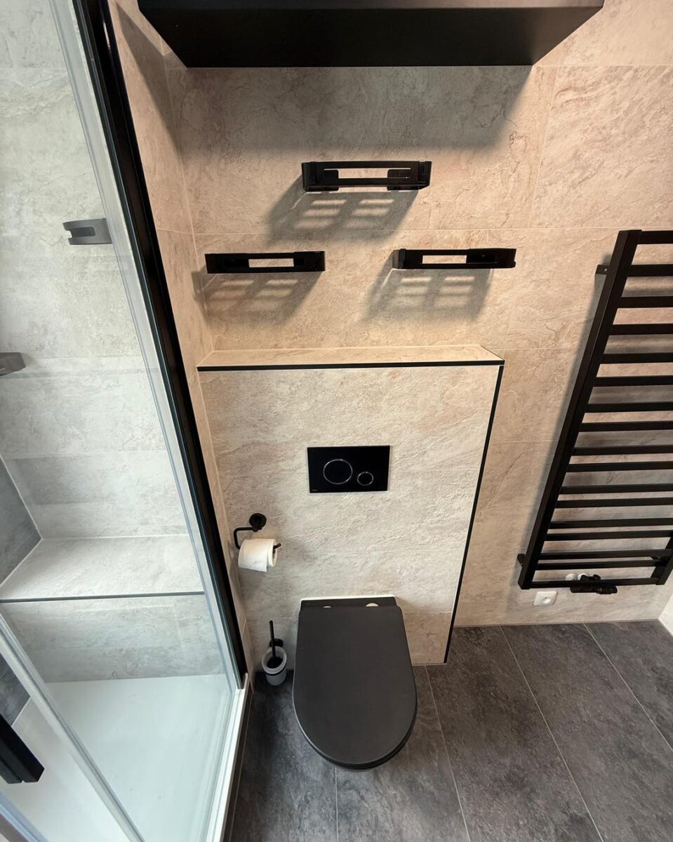 Krásná koupelna s velkoformátovými obklady v dekoru břidlice a černými zařizovacími předměty (Most)