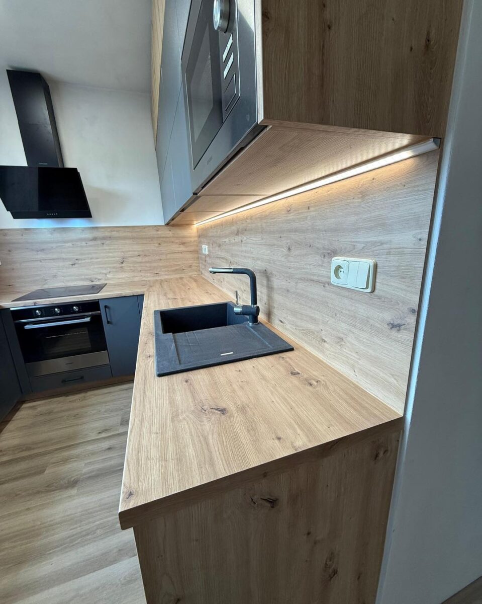 Tmavá kuchyně v kombinaci s dřevodekorem do U (Kadaň)