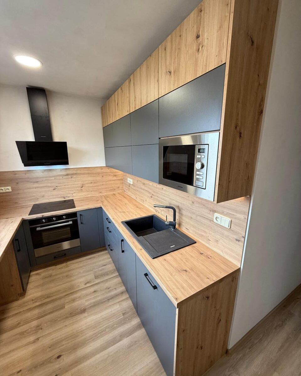 Tmavá kuchyně v kombinaci s dřevodekorem do U (Kadaň)