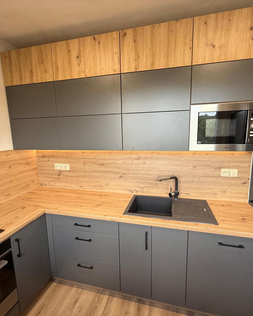 Tmavá kuchyně v kombinaci s dřevodekorem do U (Kadaň)