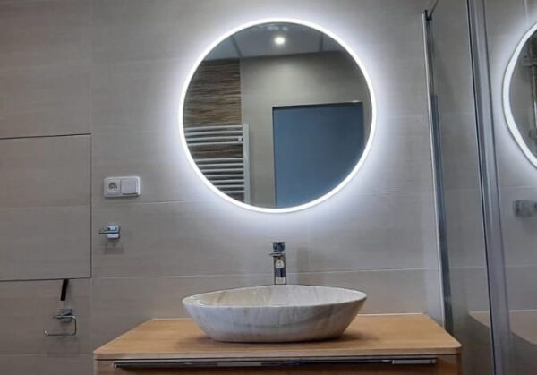 Koupelna plná teplých barev s výraznými prvky jako je podsvícené zrcadlo a mramorové umyvadlo (Most)