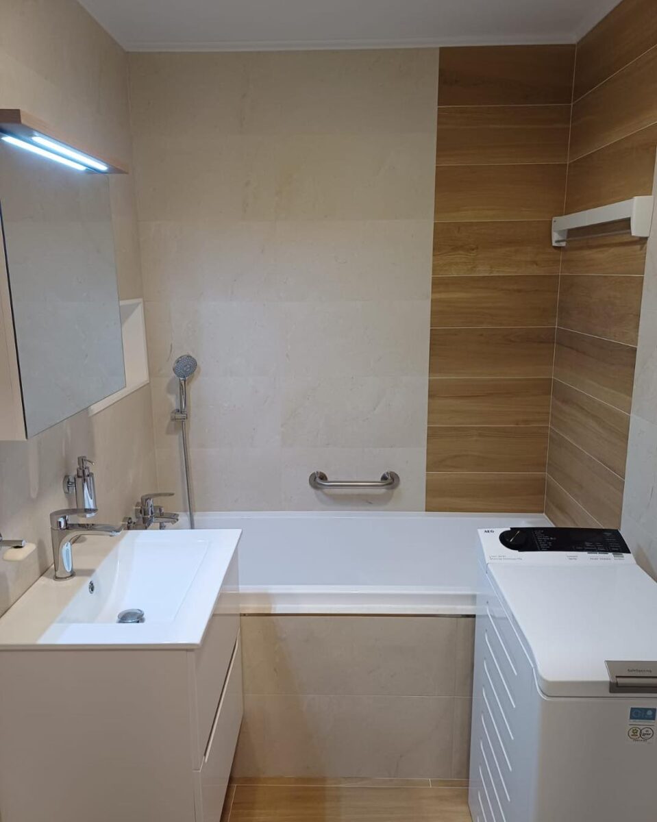 Koupelna v béžových barvách spolu s dekorem dřeva s praktickou nikou (Most)