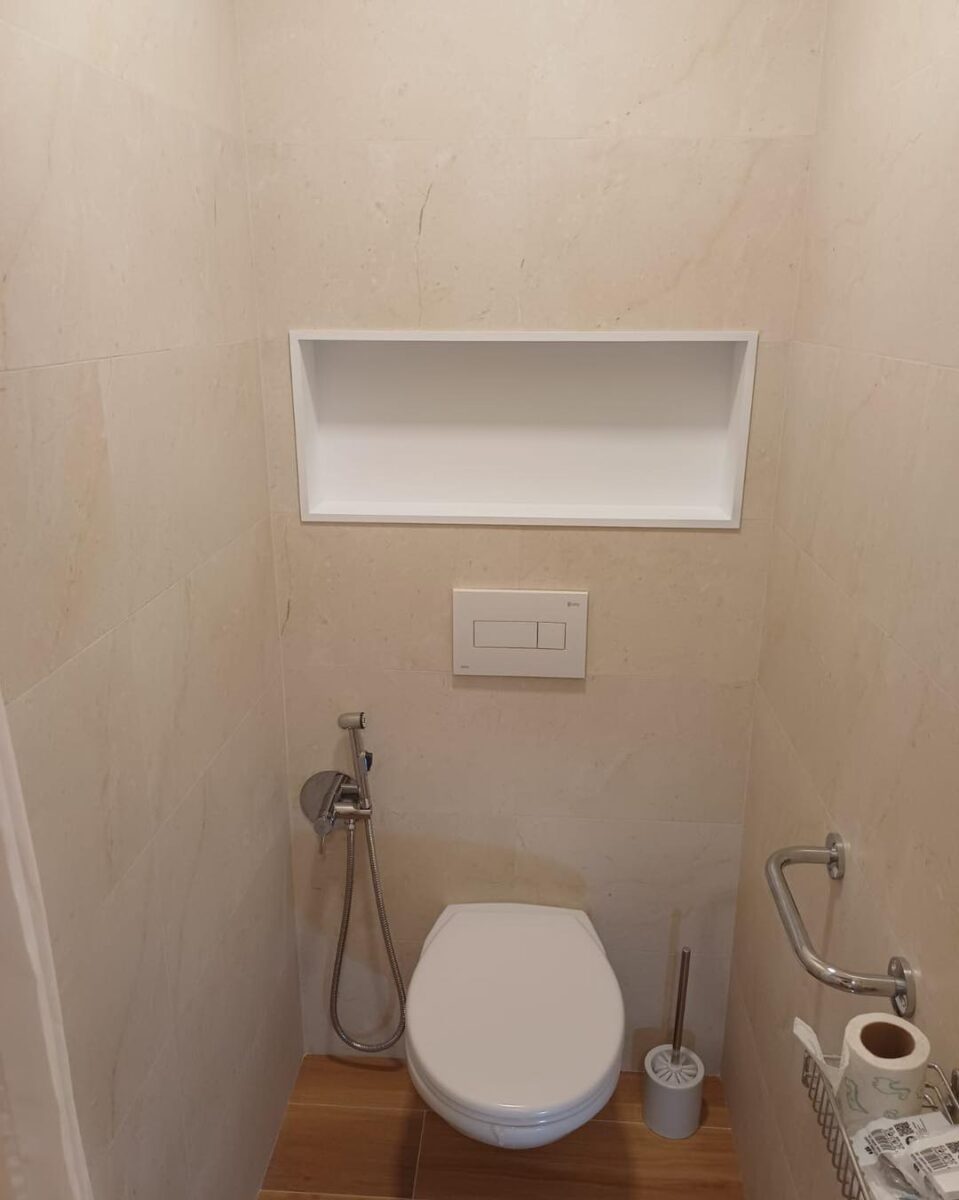 Koupelna v béžových barvách spolu s dekorem dřeva s praktickou nikou (Most)