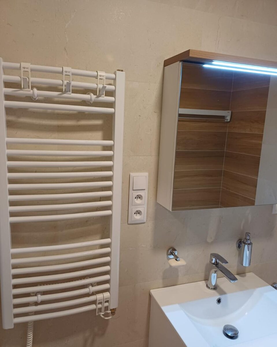 Koupelna v béžových barvách spolu s dekorem dřeva s praktickou nikou (Most)