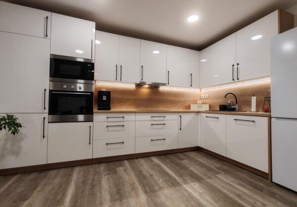 Kuchyň do L v dekoru dřeva v kombinaci s vysokým leskem je nadčasová kombinace (Most)