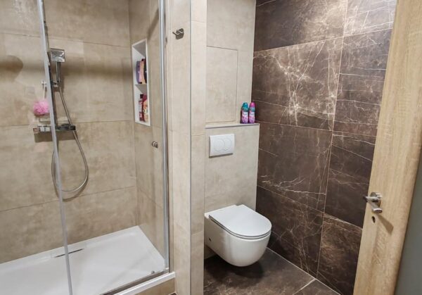 Krásná velkoformátová koupelna s rektifikovanými obklady se sprchovým koutem se sedátkem (Most)