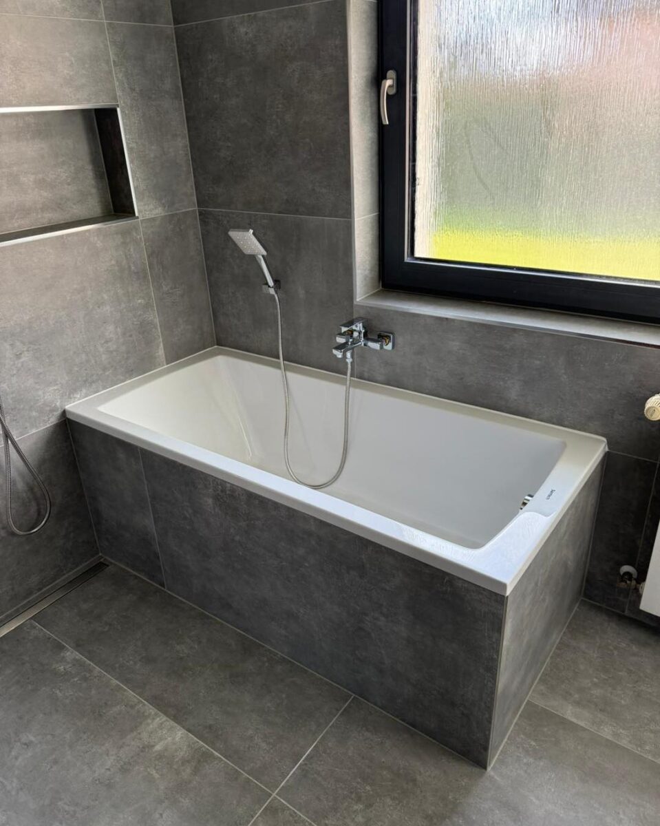 Atypická tmavá koupelna s walk-in sprchou hned vedle vany (Chomutov)