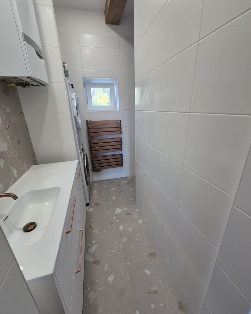 Koupelna s měděnými prvky a béžovošedými obklady s trendy nikami a bidetovou sprškou (Most)