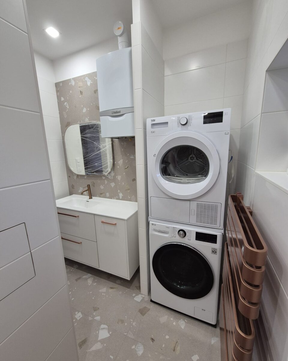 Koupelna s měděnými prvky a béžovošedými obklady s trendy nikami a bidetovou sprškou (Most)